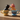 Two ceramic dog figurines in teacups with floral designs on a textured beige background
