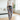 Person wearing colorful cat-patterned pajama pants in a living room.