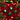 Four Christmas-themed hoop earrings displayed on a red velvet surface with pine branches, red berries, gold stars, and blurred holiday lights in the background. Two earrings feature green tinsel wreaths with white Santa faces, and two feature green tinsel wreaths with black Santa faces.