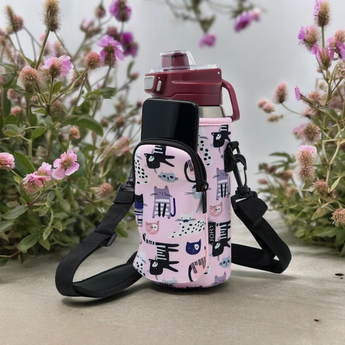 Cat Lover On The Go Crossbody Bag in Use: The crossbody bag being worn, with the front zipper pocket holding a phone and the main pocket containing a bottle, showing the bag's versatility and functionality.