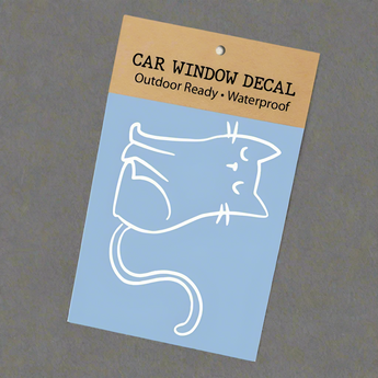 Close-up of a playful white cat-shaped vinyl sticker with curled tail and whiskers, perfectly sized for car windows or bumpers.