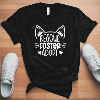 Black unisex Rescue Foster Adopt T-Shirt with playful white font and cat face outline, available in sizes S-2XL.