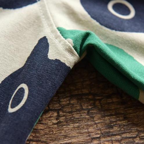 Close up of the abstract cat print shirt in blue and green colors.