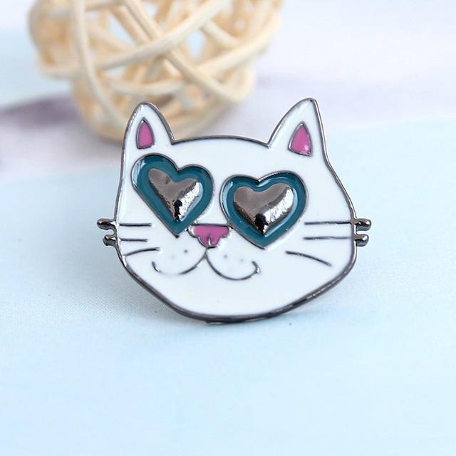 This cat brooch features a white cat with cute pink ears and nose wearing heart-shaped sunglasses.
